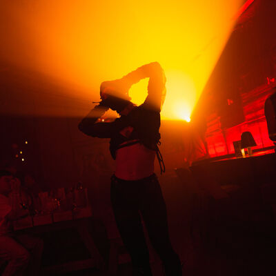 Dancer performing under orange stage lighting