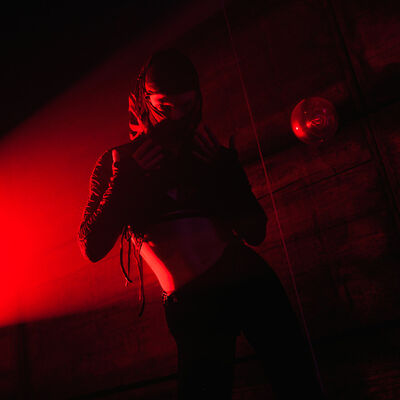 Dancer performing under red stage lighting