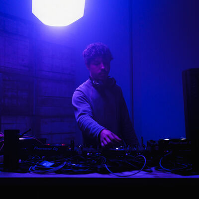 DJ performing under blue stage lighting