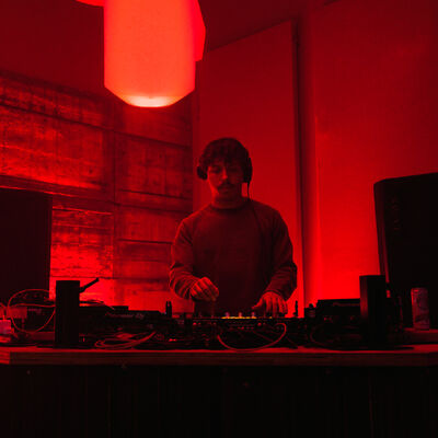 DJ performing under red stage lighting