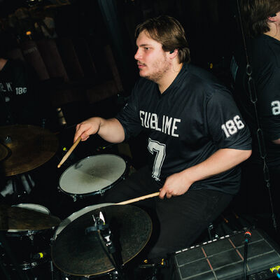 Drummer performing while wearing a football shirt